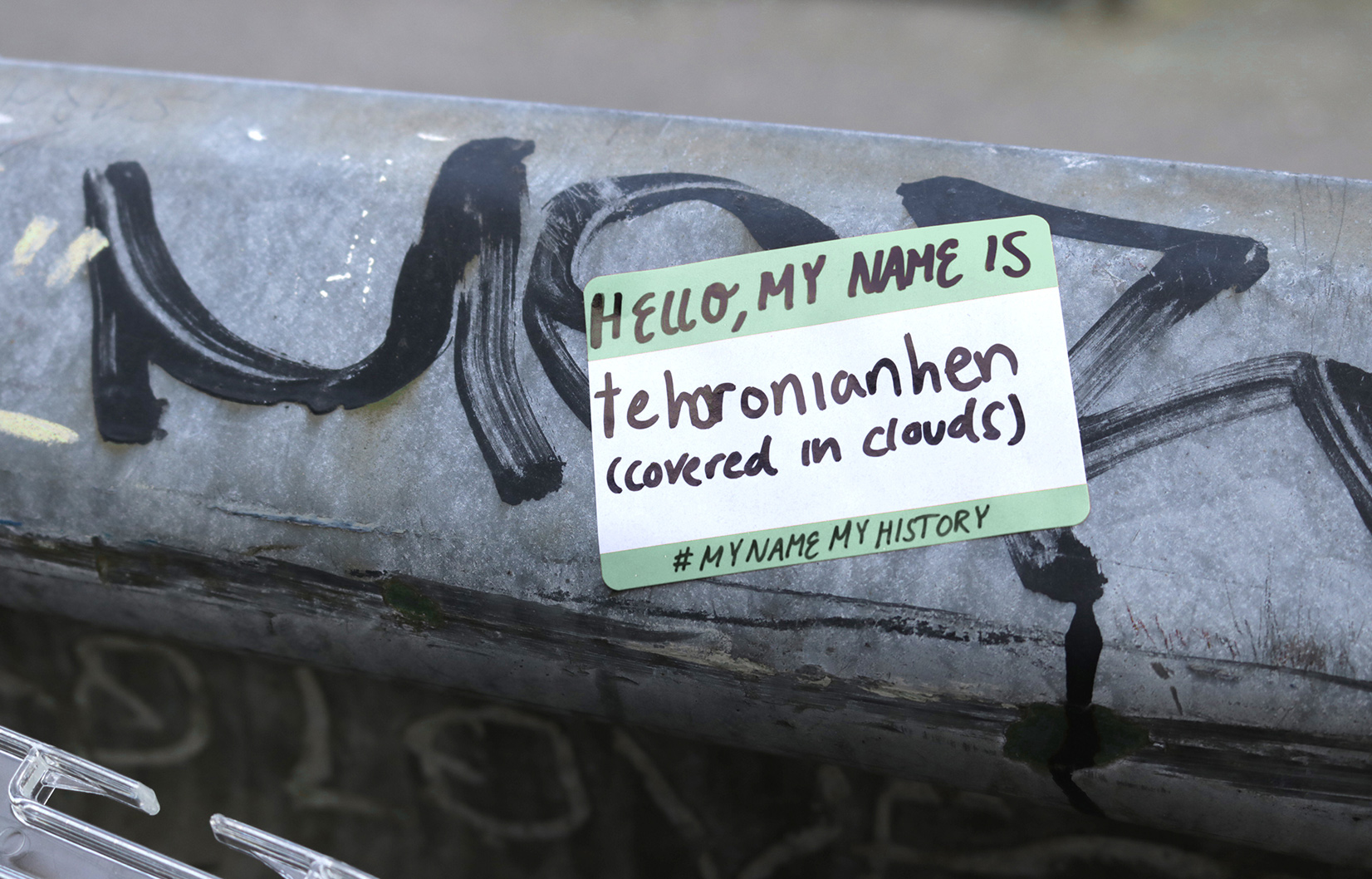 A hello my name is guerilla campaign sticker placed on a railing. The name reads Tehoronianhen.