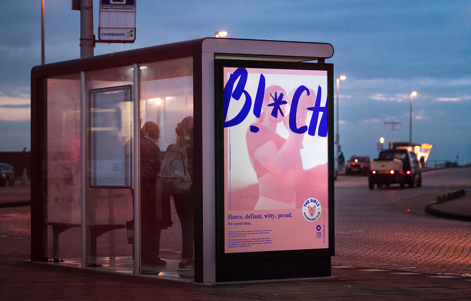 A pink empowering girls kickboxing poster at a bus stop.